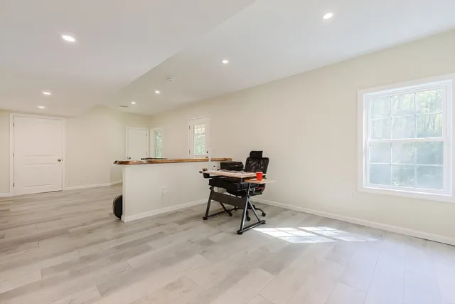 a view of a workspace with furniture and a window