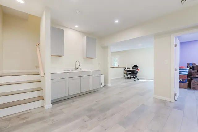 a view of a kitchen with a sink and dishwasher with white cabinets