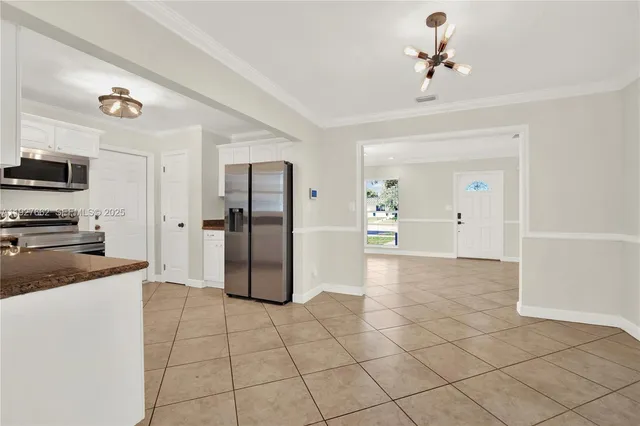 a view of a kitchen with a sink and an empty room