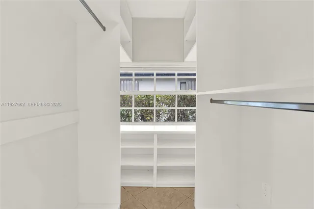 a view of walk in closet with empty racks