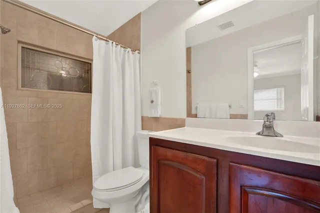 a bathroom with a sink toilet vanity and shower