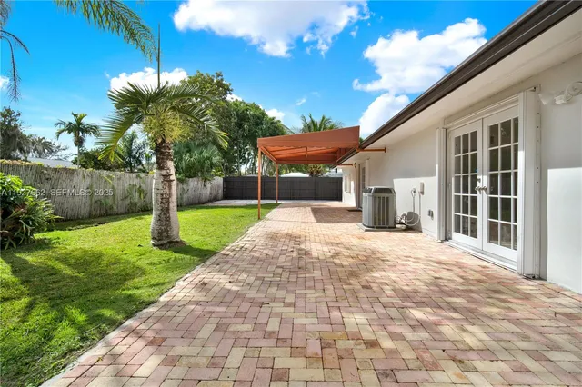 a front view of a house with a yard and potted plants