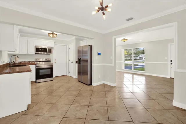 a kitchen with granite countertop a refrigerator and a stove top oven