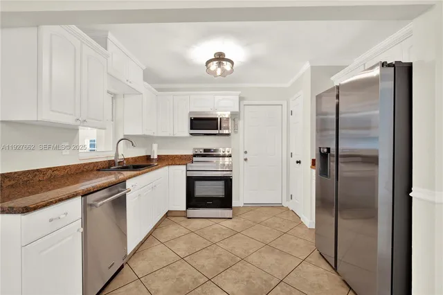 a kitchen with stainless steel appliances granite countertop a refrigerator sink and stove
