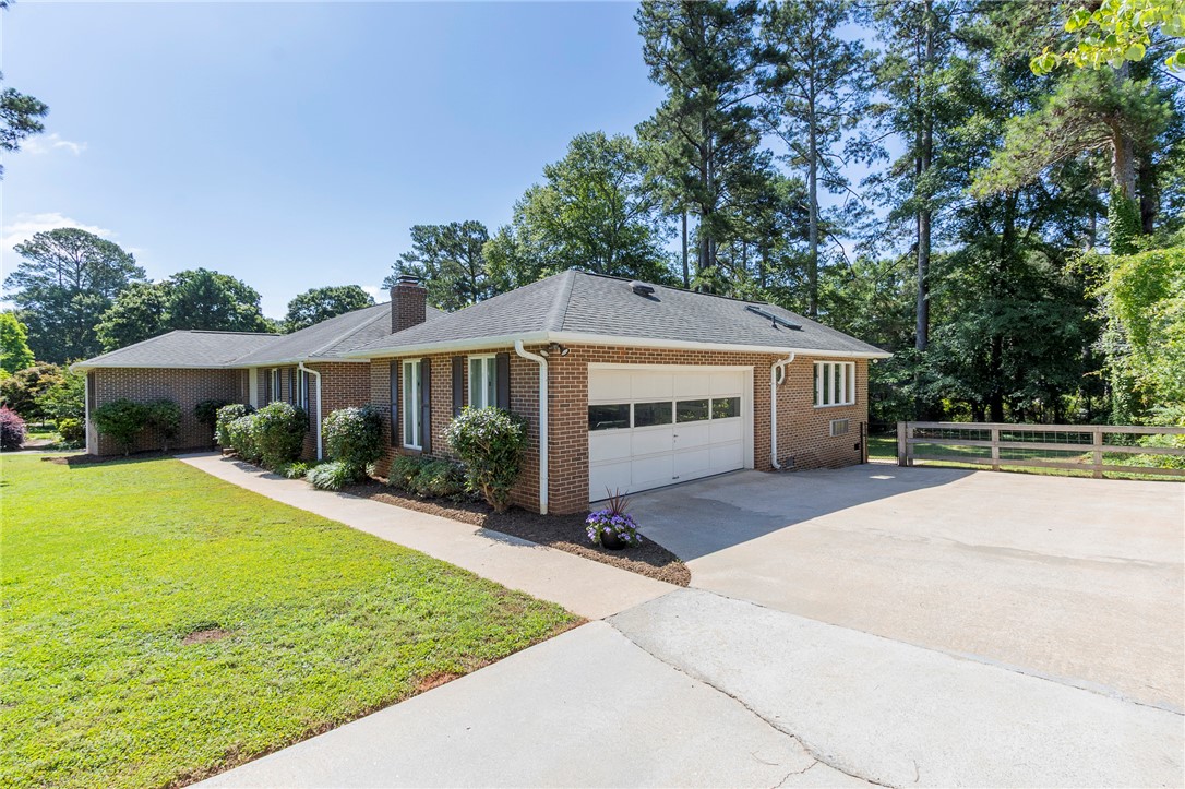 207 Laurel Ridge Road Anderson, SC 29621 - Photo 5 of 50 A classic brick exterior and welcoming driveway define this charming residence, framed by mature trees.