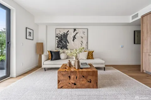 a living room with furniture and a wall painting