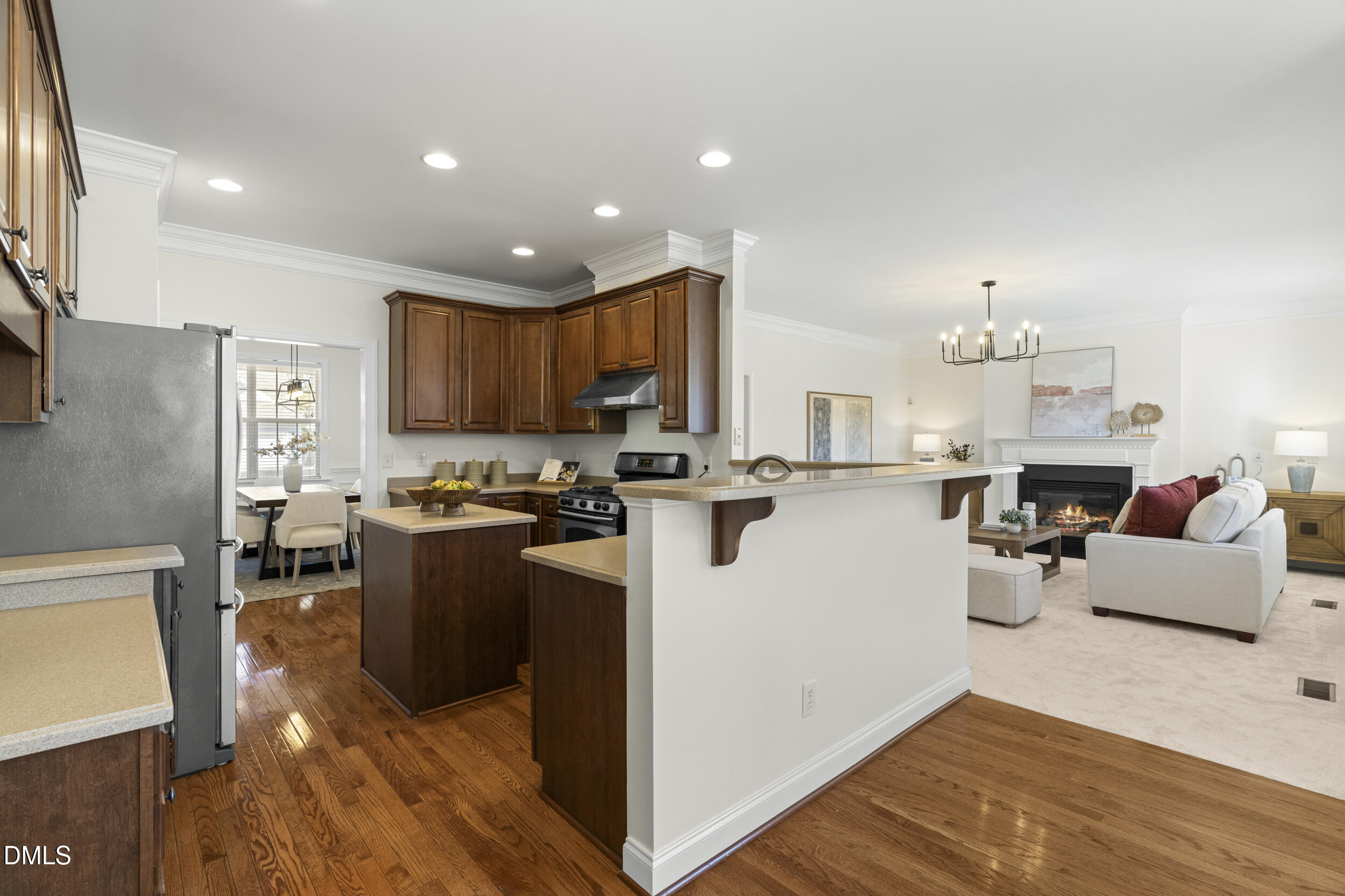 105 Bayless Ridge Court Morrisville, NC 27560 - Photo 14 of 42 a kitchen with stainless steel appliances granite countertop a refrigerator oven a sink dishwasher a dining table and chairs with wooden floor