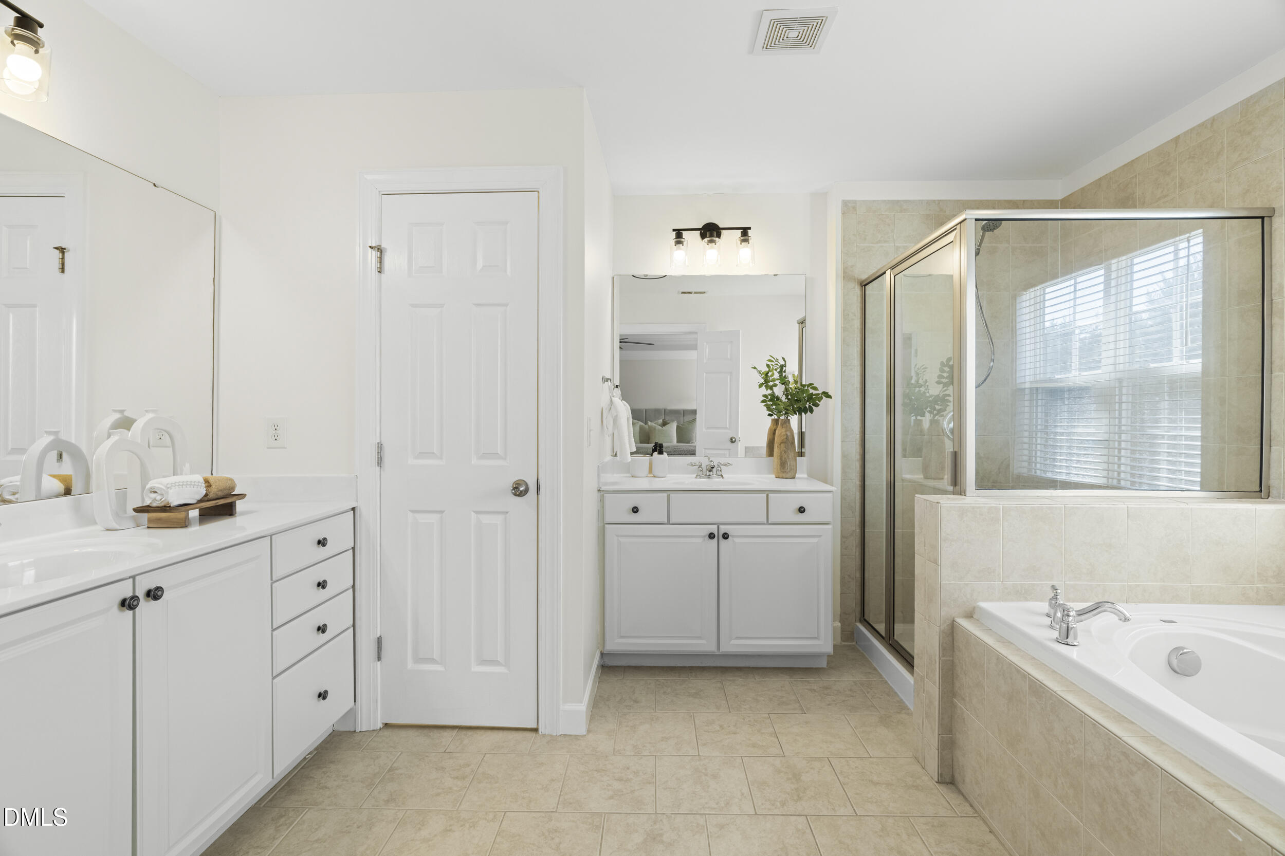 105 Bayless Ridge Court Morrisville, NC 27560 - Photo 28 of 43 a spacious bathroom with a double vanity sink a mirror a bathtub and next to a window