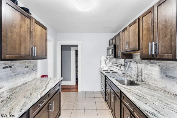 a kitchen with stainless steel appliances granite countertop a sink stove and cabinets