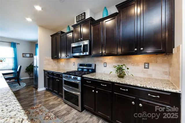 a dining room with furniture a kitchen view and a large window