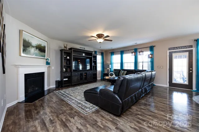 a living room with furniture a ceiling fan and a rug