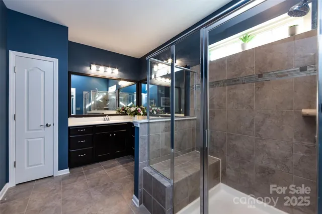 a en suite bathroom with a double vanity sink and mirror