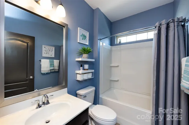 a view of a hallway with wooden floor and a living room
