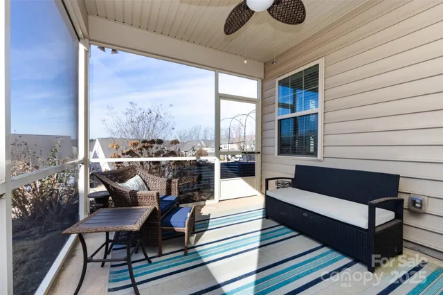 a living room with furniture and a floor to ceiling window