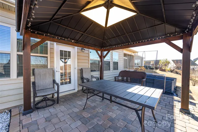 a view of a roof deck with table and chairs under an umbrella