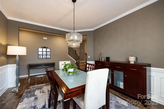 a view of a dining room and a livingroom with furniture wooden floor a chandelier