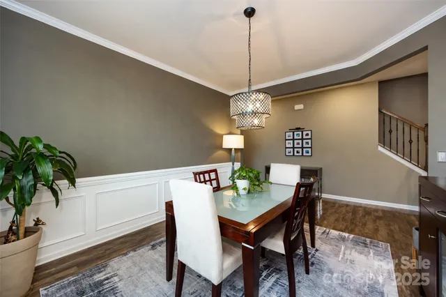 a kitchen with stainless steel appliances granite countertop a refrigerator a sink dishwasher a stove and a dining table with wooden floor