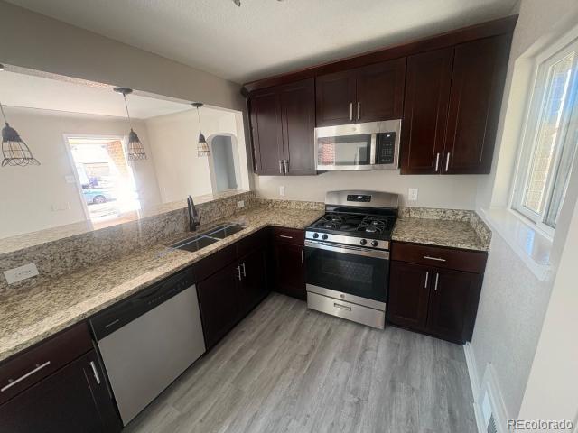 3290 Magnolia Street Denver, CO 80207 - Photo 2 of 15 a kitchen with granite countertop stainless steel appliances and wooden cabinets