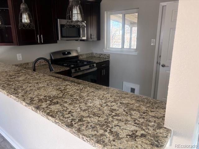 3290 Magnolia Street Denver, CO 80207 - Photo 4 of 15 a kitchen with a sink a stove and cabinets