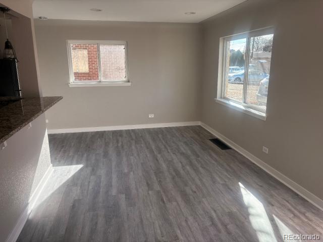 3290 Magnolia Street Denver, CO 80207 - Photo 6 of 15 an empty room with wooden floor and windows