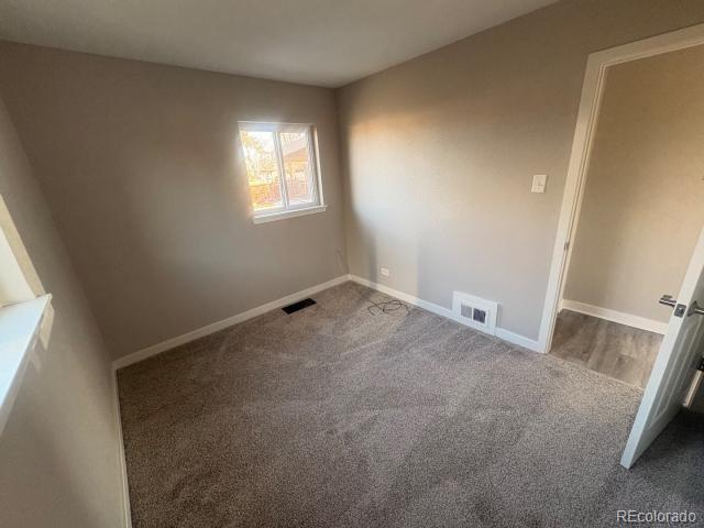3290 Magnolia Street Denver, CO 80207 - Photo 8 of 15 an empty room with a fireplace and windows