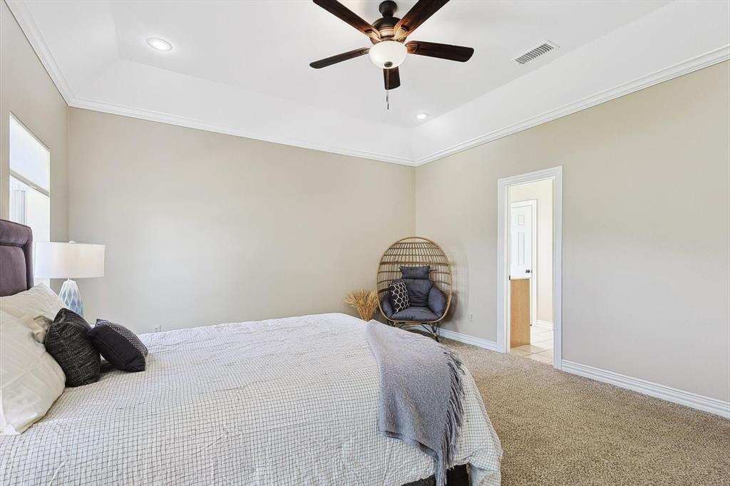 3289 Mitchell Road Krum, TX 76249 - Photo 15 of 38 a bedroom with a bed and a chandelier