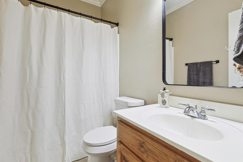 3289 Mitchell Road Krum, TX 76249 - Photo 19 of 38 a bathroom with a sink and a mirror