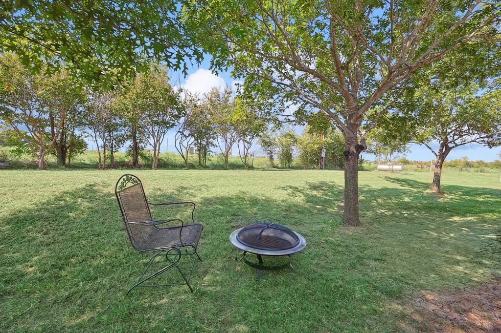 3289 Mitchell Road Krum, TX 76249 - Photo 27 of 38 a view of a backyard with table and chairs