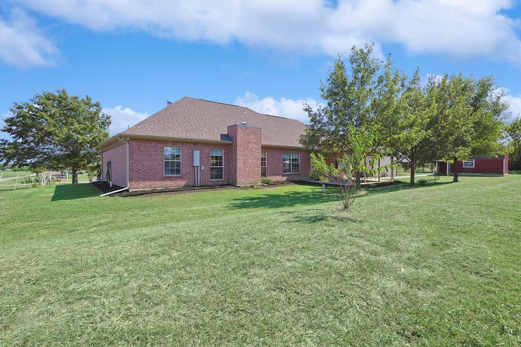 3289 Mitchell Road Krum, TX 76249 - Photo 29 of 38 a brick house with a big yard and large trees