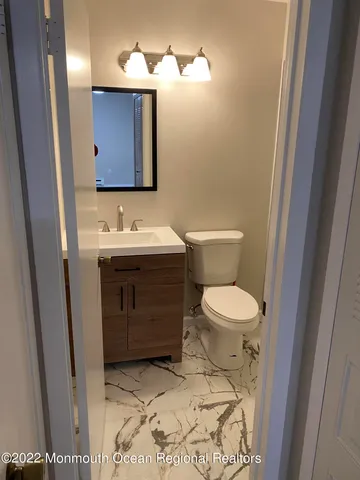 a bathroom with a toilet sink and mirror