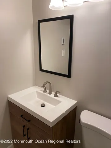 a bathroom with a sink a toilet and mirror