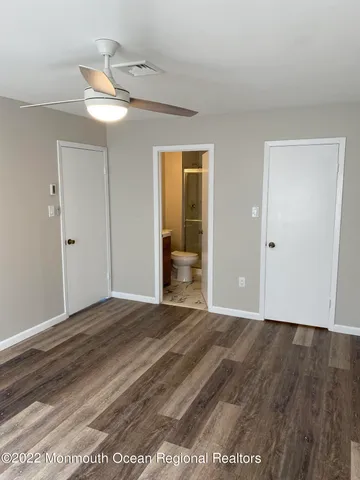 a view of a room with wooden floor and white walls