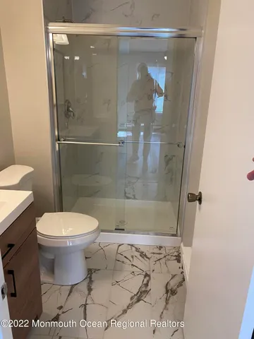 a bathroom with a toilet and a shower