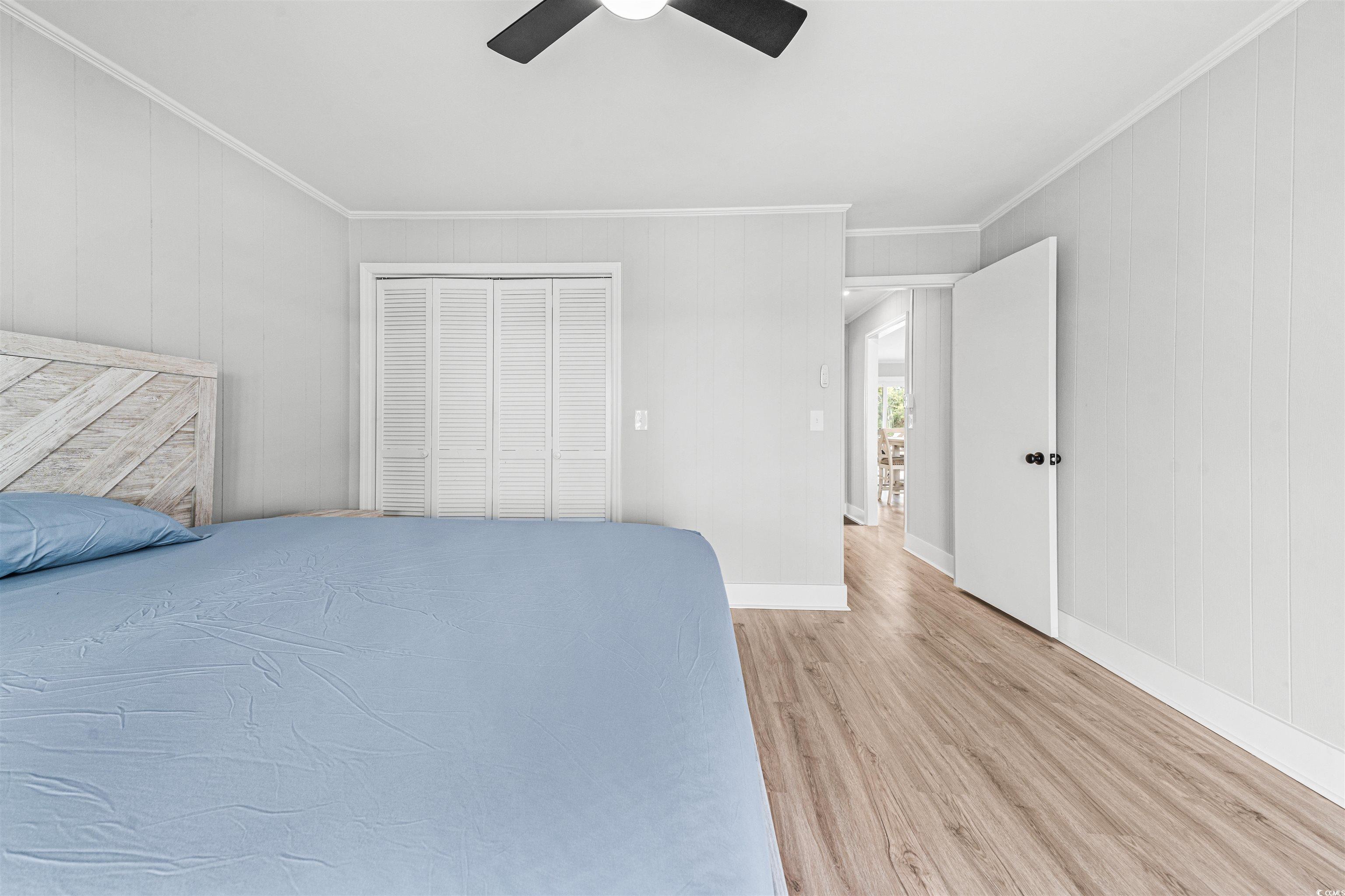 338 State Rd S-26-530 Murrells Inlet, SC 29576 - Photo 31 of 39 Unfurnished bedroom with crown molding, baseboards, ceiling fan, light wood-style flooring, and a closet