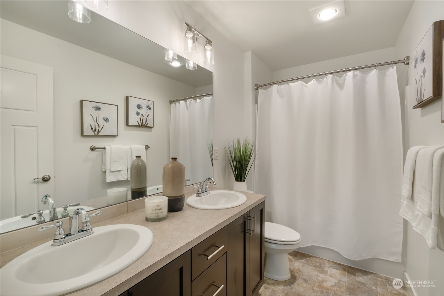 5525 Northeast 7th Place Renton, WA 98059 - Photo 21 of 30 a bathroom with a double vanity sink toilet and a mirror