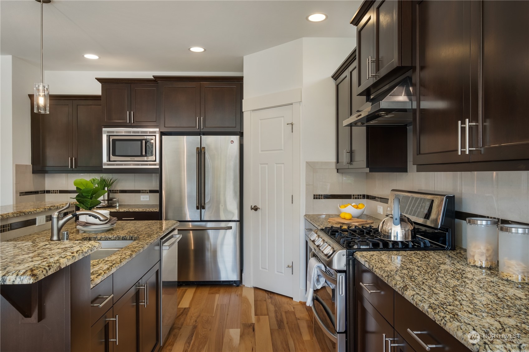 5525 Northeast 7th Place Renton, WA 98059 - Photo 9 of 30 a kitchen with granite countertop stainless steel appliances and wooden cabinets