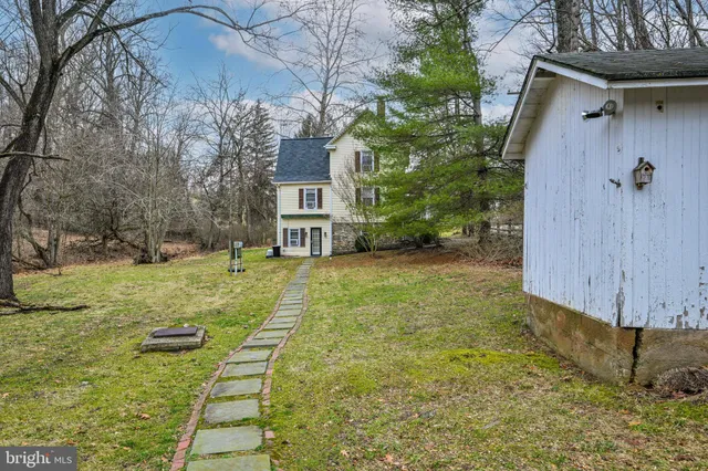 a view of a backyard with brick wall and plants
