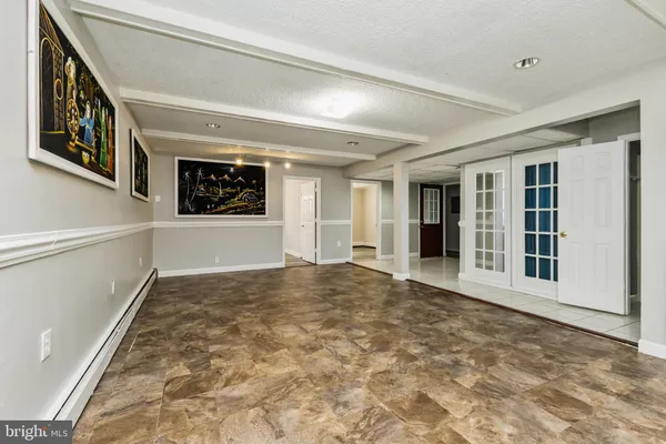 a view of an empty room with wooden floor and window