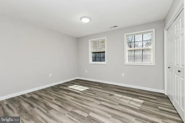 a view of a room with wooden floor and windows