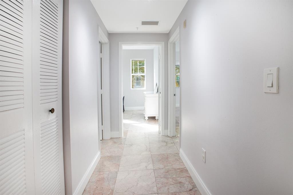 5860 West Sample Road, Unit 204 Coral Springs, FL 33067 - Photo 11 of 36 a view of a hallway with a white walls