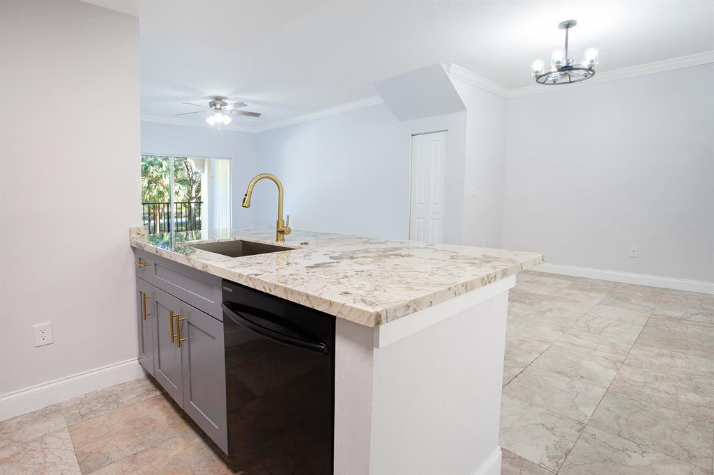 5860 West Sample Road, Unit 204 Coral Springs, FL 33067 - Photo 9 of 36 a kitchen with granite countertop a sink and a stove