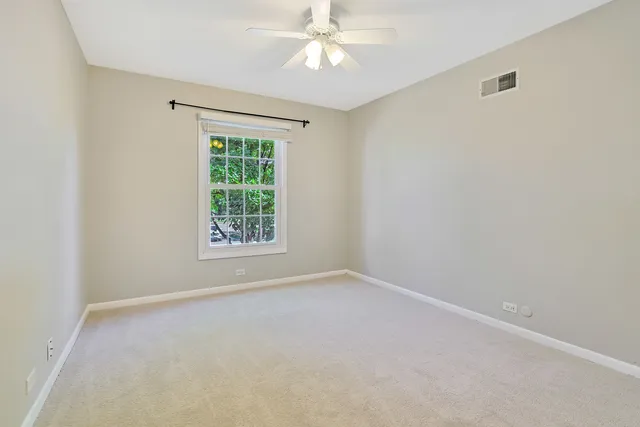 an empty room with a ceiling fan and bathroom