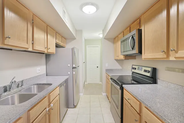 a kitchen with a sink a stove top oven a refrigerator and a window