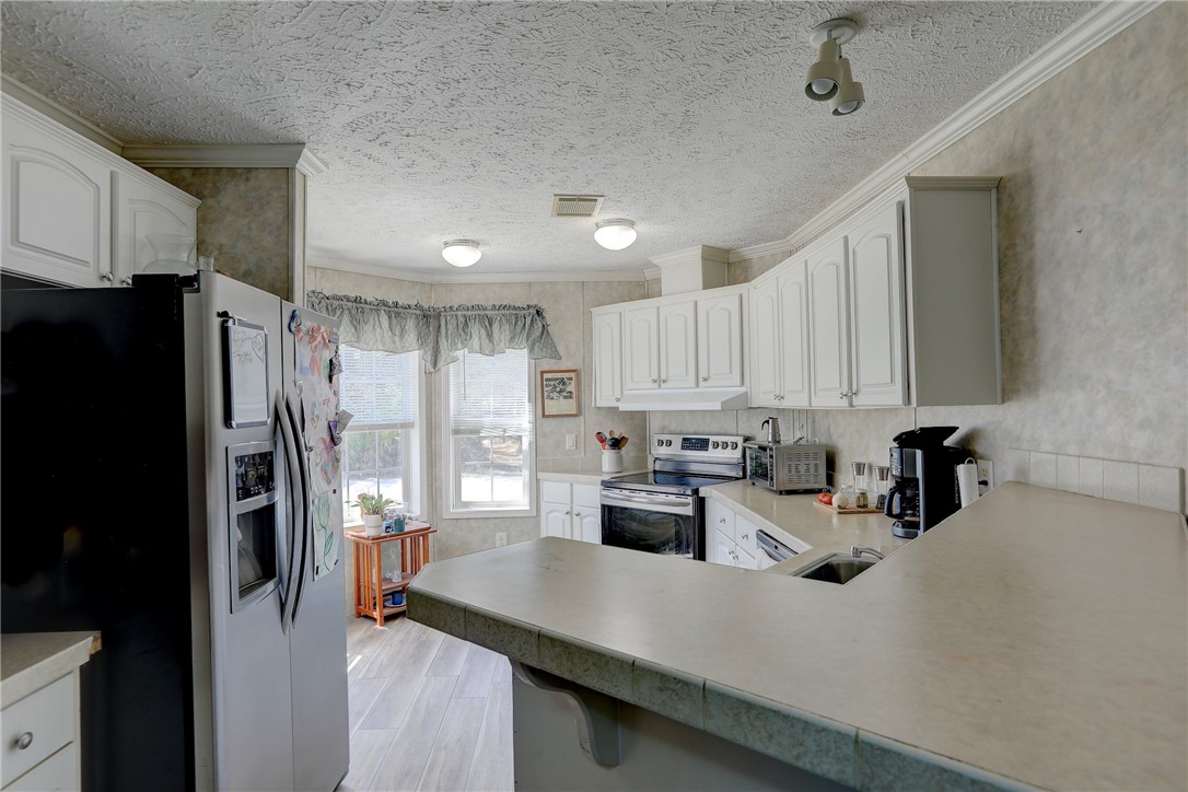 7820 Russell Street Sebastian, FL 32958 - Photo 11 of 36 a kitchen with refrigerator and cabinets