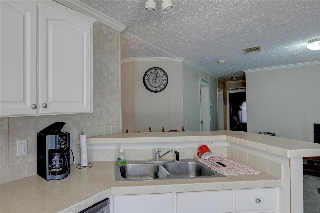 7820 Russell Street Sebastian, FL 32958 - Photo 12 of 36 a kitchen with a sink and a clock on the wall