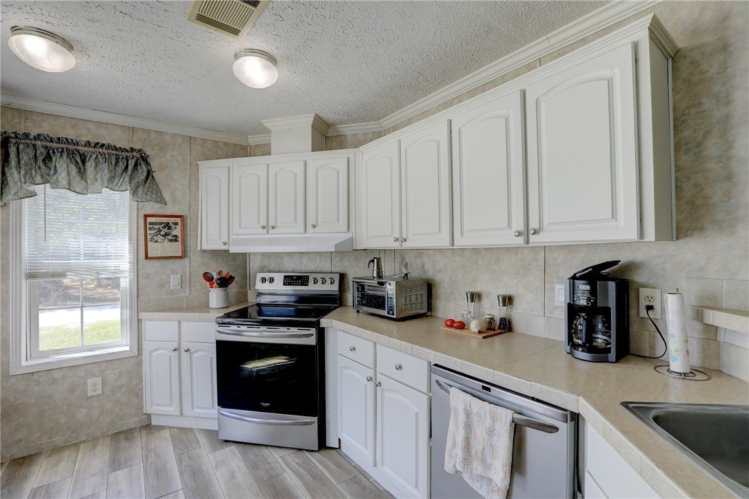7820 Russell Street Sebastian, FL 32958 - Photo 13 of 36 a kitchen with white cabinets and white appliances