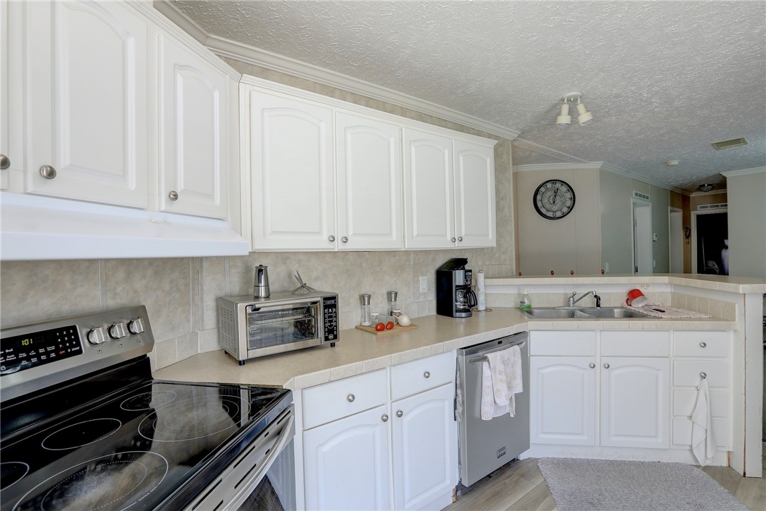 7820 Russell Street Sebastian, FL 32958 - Photo 14 of 36 a kitchen with a sink stove and cabinets