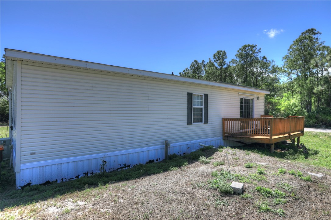 7820 Russell Street Sebastian, FL 32958 - Photo 4 of 36 a backyard of a house with wooden fence and large trees