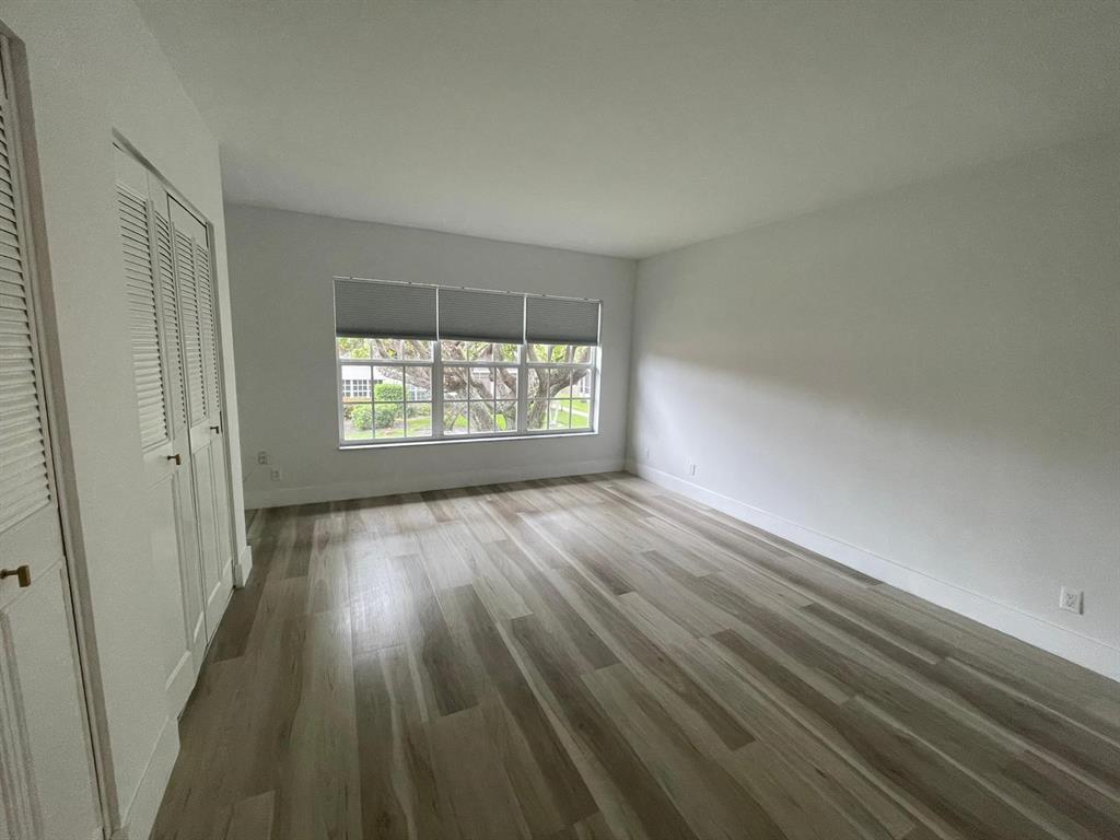 250 Northeast 20th Street, Unit 210 Boca Raton, FL 33431 - Photo 21 of 50 an empty room with wooden floor and windows