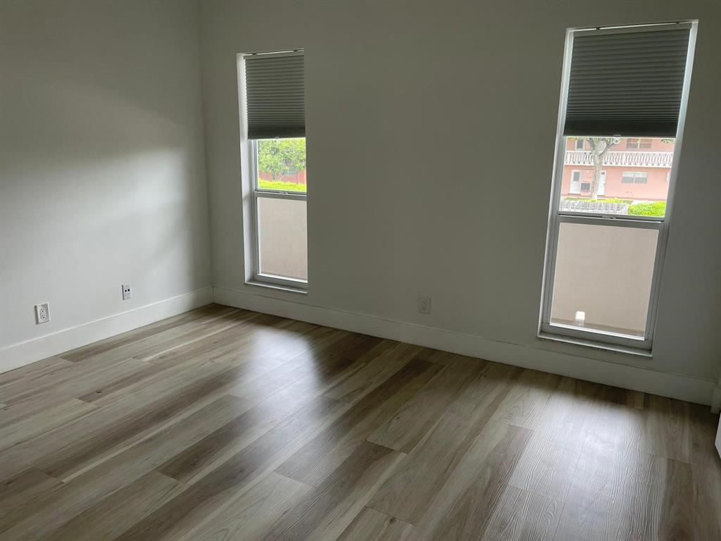 250 Northeast 20th Street, Unit 210 Boca Raton, FL 33431 - Photo 31 of 50 an empty room with wooden floor and windows